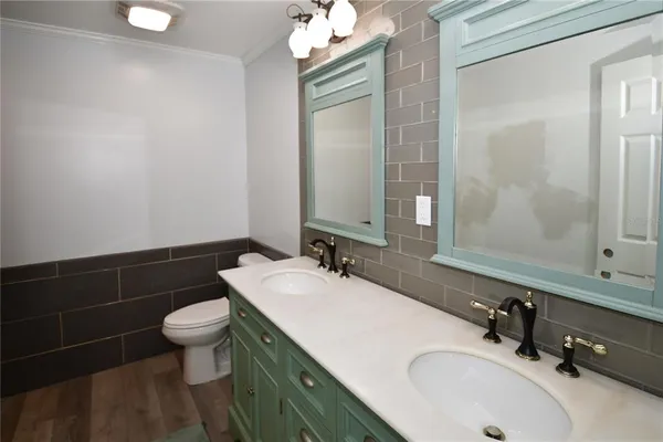 a bathroom with a sink vanity granite toilet and a mirror