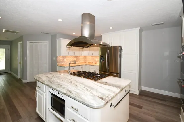 a kitchen with a stove and wooden floor