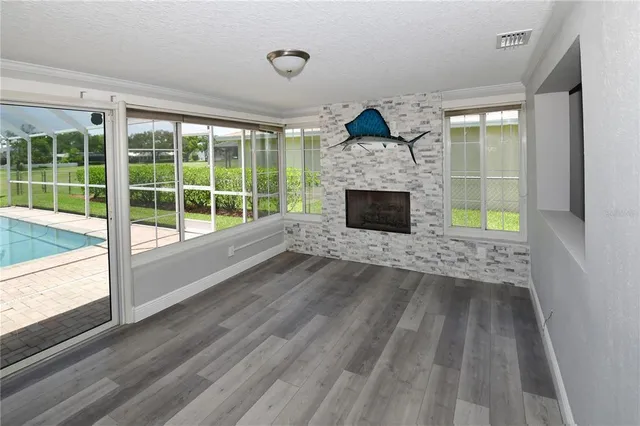 a view of empty room with wooden floor and fireplace