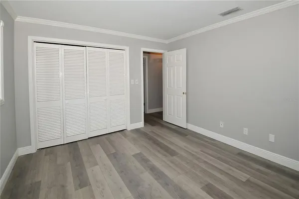 a view of an empty room with wooden floor