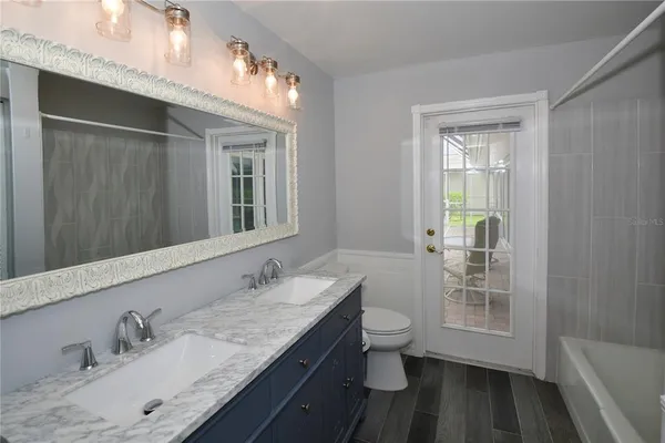 a bathroom with a granite countertop sink a toilet and a mirror