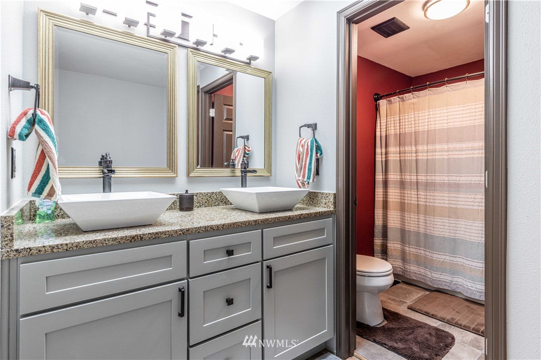 25904 202nd Avenue Southeast Covington, WA 98042 - Photo 16 of 24 a bathroom with a granite countertop sink mirror vanity and toilet