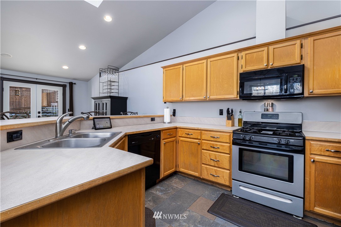 25904 202nd Avenue Southeast Covington, WA 98042 - Photo 9 of 24 a kitchen with stainless steel appliances granite countertop a stove a sink and a microwave