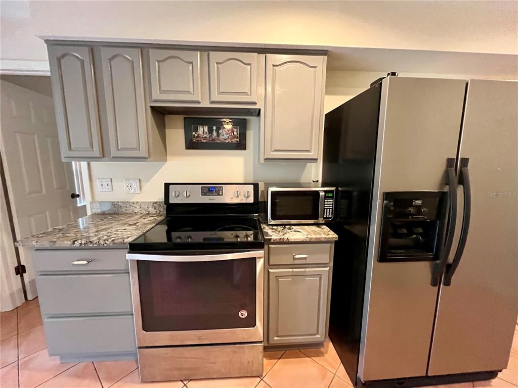 6604 Flicker Court Seffner, FL 33584 - Photo 13 of 32 a kitchen with stainless steel appliances granite countertop a stove a refrigerator and a microwave
