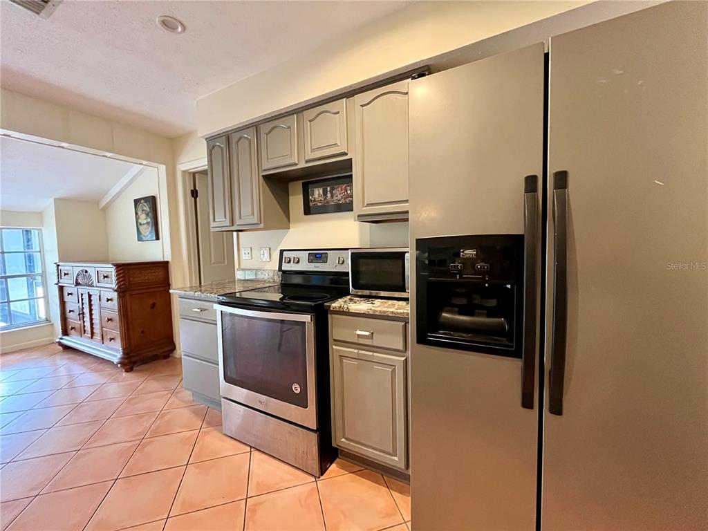 6604 Flicker Court Seffner, FL 33584 - Photo 15 of 32 a kitchen with stainless steel appliances granite countertop a stove a sink and a refrigerator