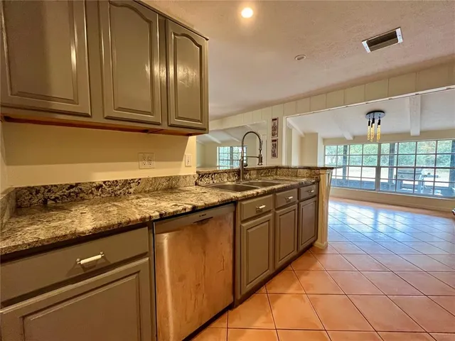 a kitchen with stainless steel appliances granite countertop a sink stove and cabinets
