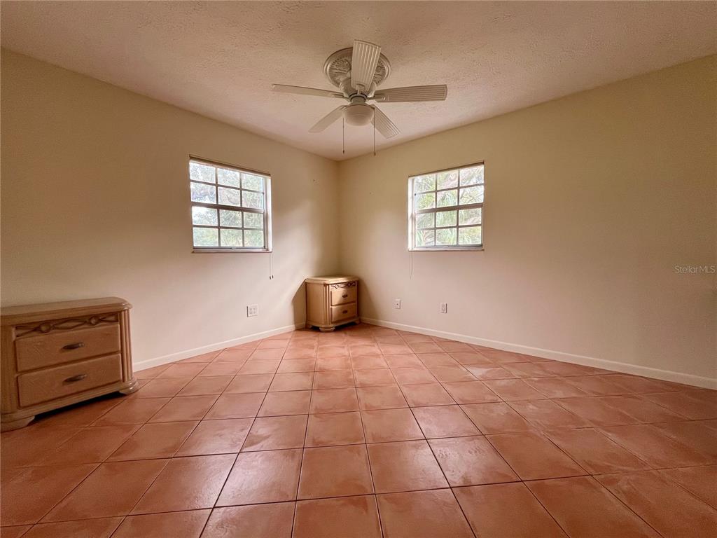 6604 Flicker Court Seffner, FL 33584 - Photo 21 of 32 a view of an empty room with a window and a ceiling fan