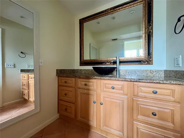 a bathroom with a granite countertop sink vanity and mirror