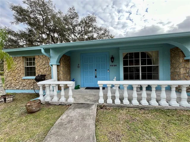 a view of a house with a yard and sitting area