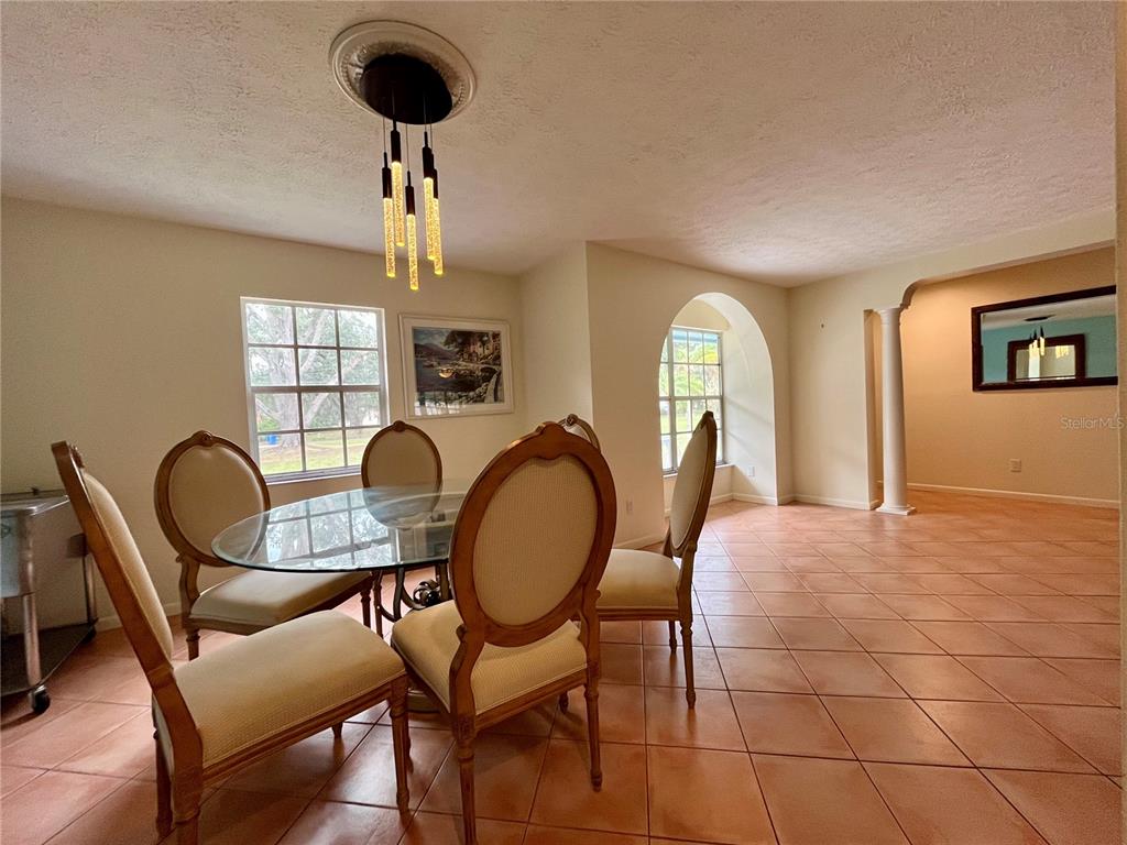 6604 Flicker Court Seffner, FL 33584 - Photo 7 of 32 a view of a dining room with furniture a chandelier and window