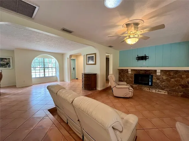a living room with furniture a fireplace and a window