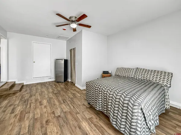 a bedroom with a bed and wooden floor