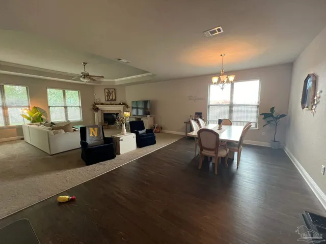 a kitchen with a table chairs a sink dishwasher stove and cabinets with wooden floor