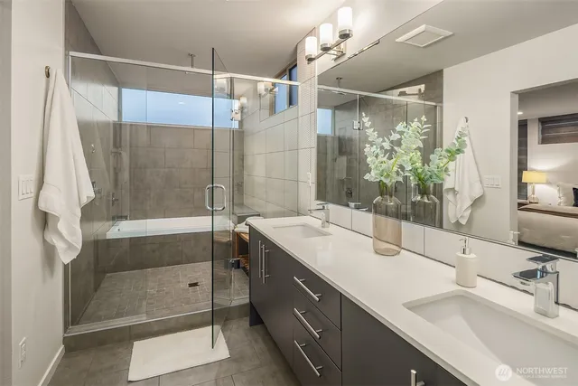 a bathroom with a double vanity sink mirror and shower