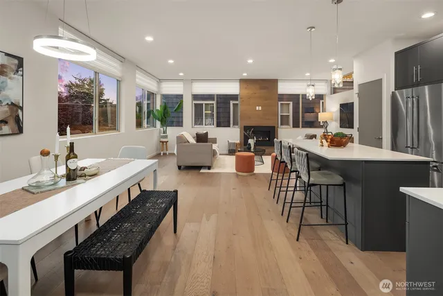 a large dining hall with stainless steel appliances kitchen island granite countertop a sink and cabinets