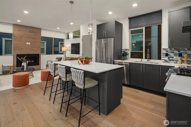 a kitchen with stainless steel appliances granite countertop a table chairs sink and cabinets