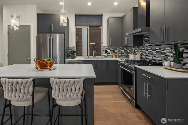 a kitchen with stainless steel appliances granite countertop a sink a stove a refrigerator with a dining table and chairs