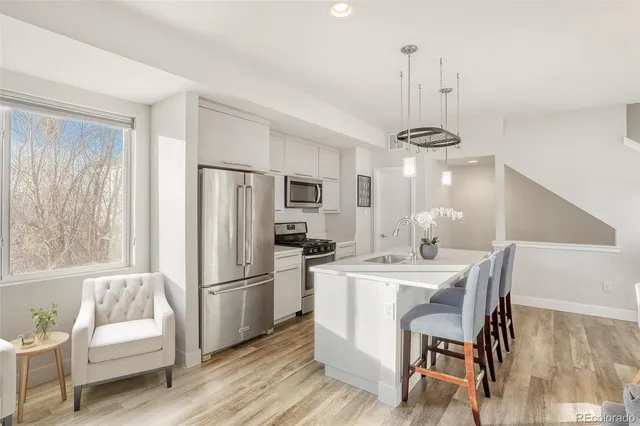 a kitchen with refrigerator a sink and chairs