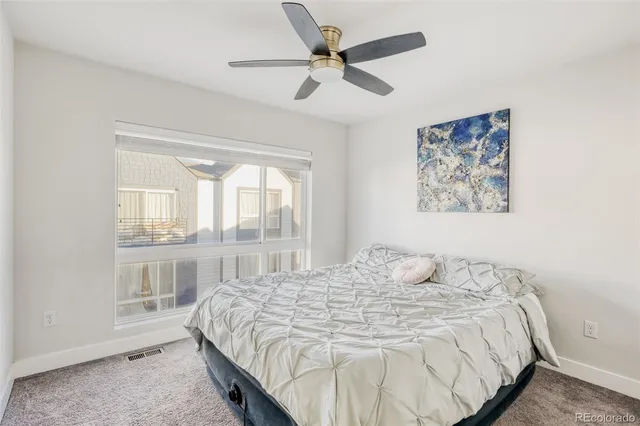 a bedroom with a bed and a large window