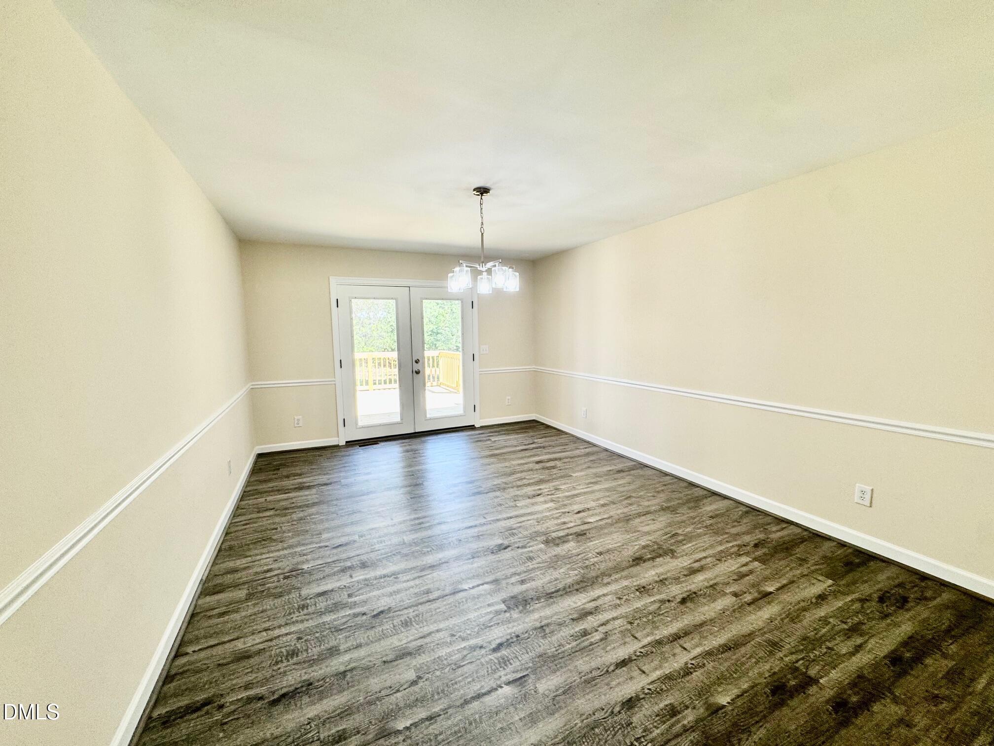 1720 Ross Mill Road Henderson, NC 27537 - Photo 15 of 42 an empty room with wooden floor and windows