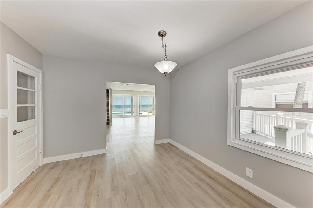 893 North Shore Drive Anna Maria, FL 34216 - Photo 19 of 62 a view of an empty room with wooden floor and a window