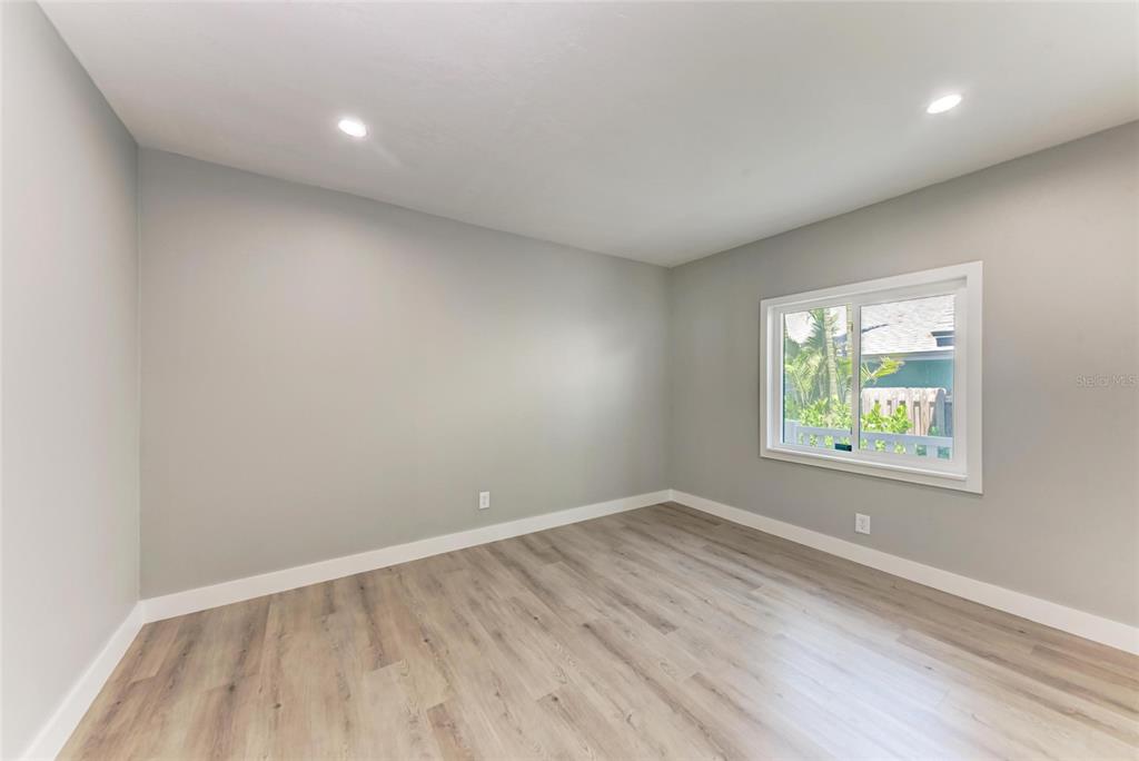 893 North Shore Drive Anna Maria, FL 34216 - Photo 22 of 62 an empty room with wooden floor and windows