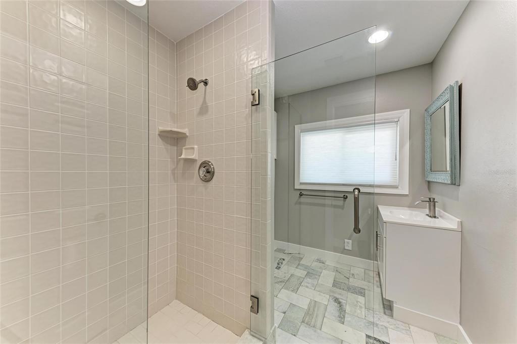 893 North Shore Drive Anna Maria, FL 34216 - Photo 25 of 62 a bathroom with a shower sink and mirror