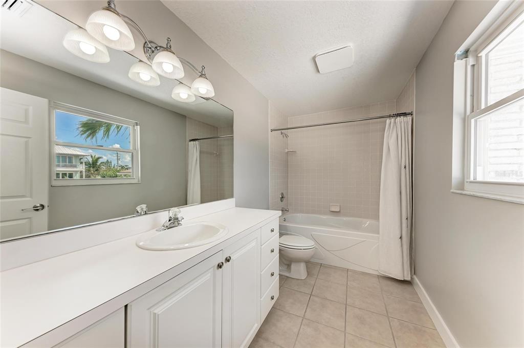 893 North Shore Drive Anna Maria, FL 34216 - Photo 35 of 62 a bathroom with a double vanity sink a toilet and a bathtub