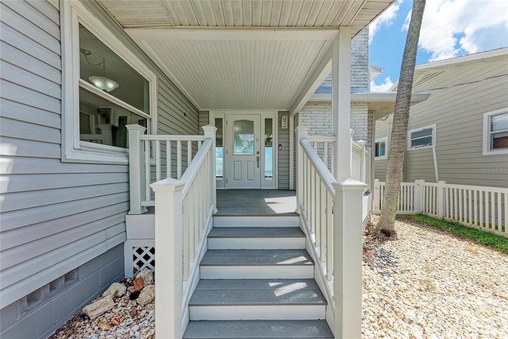893 North Shore Drive Anna Maria, FL 34216 - Photo 4 of 62 a view of staircase with lots of frames on wall and a potted plant