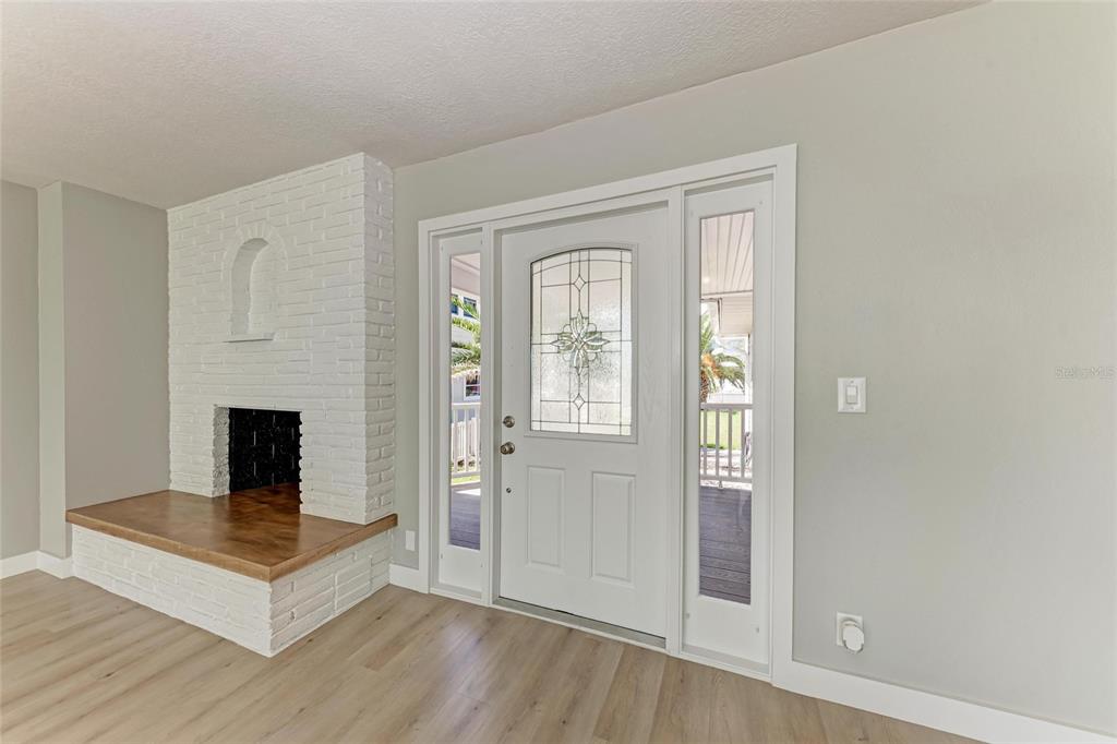 893 North Shore Drive Anna Maria, FL 34216 - Photo 7 of 62 a living room with a fireplace and wooden floor