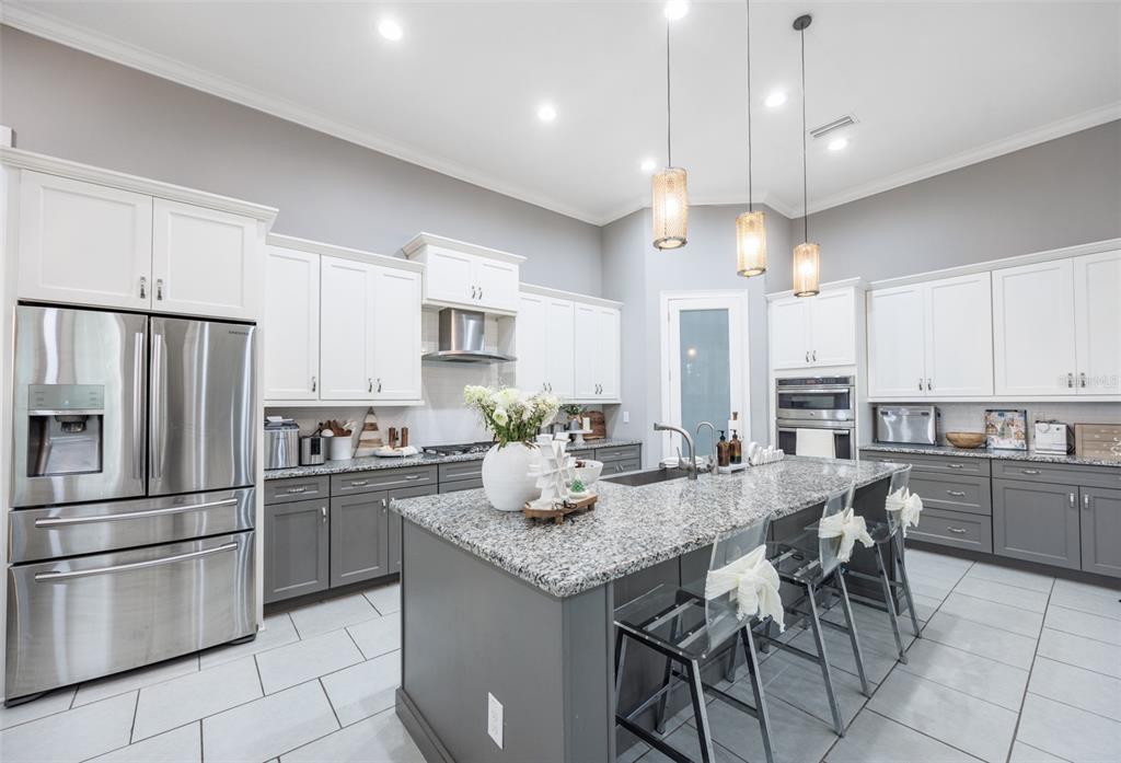 14006 Quarry Lake Road Lithia, FL 33547 - Photo 2 of 50 a kitchen with granite countertop a center island a refrigerator and a counter space