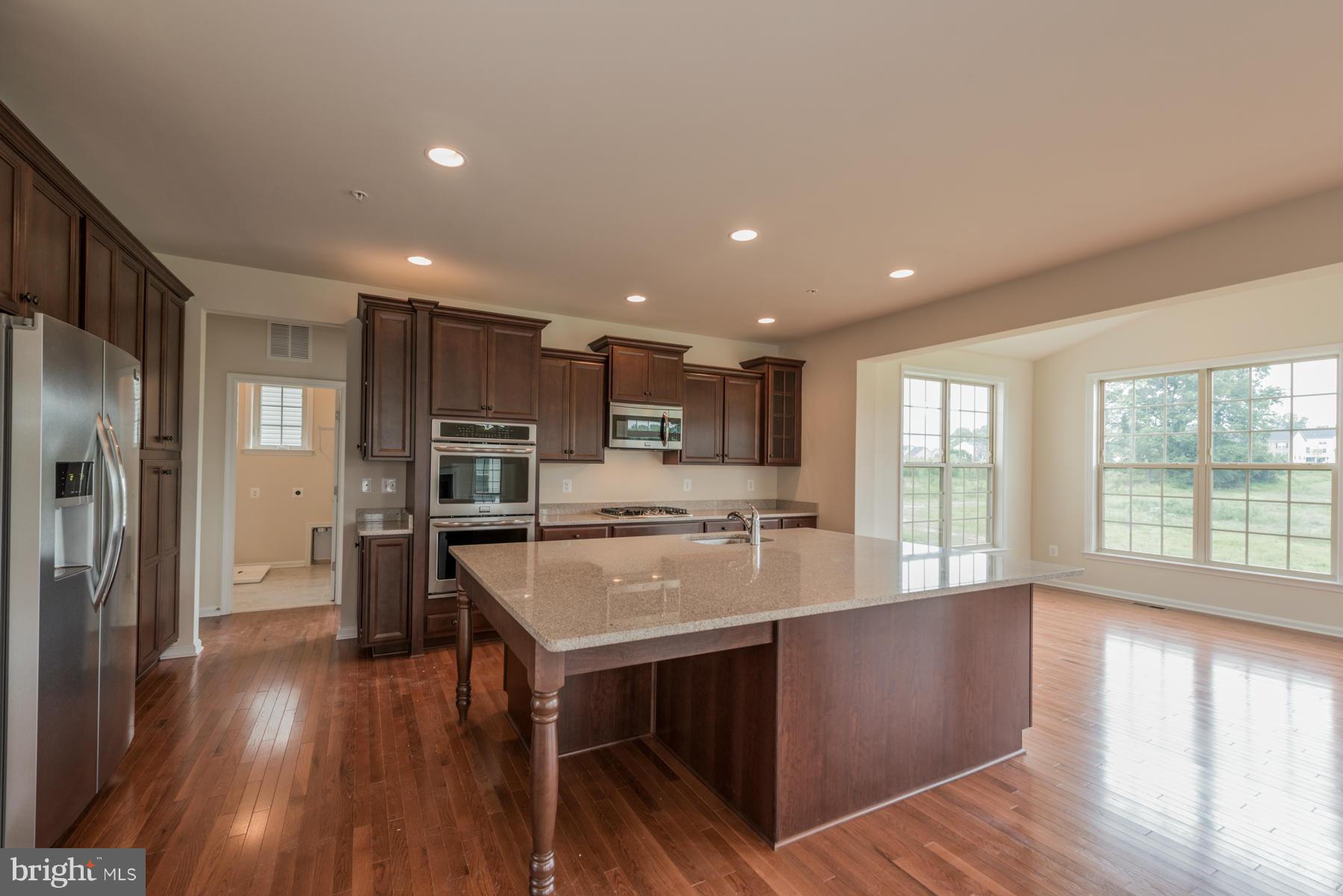 4336 Chapel Road Perry Hall, MD 21128 - Photo 3 of 30 a kitchen with kitchen island wooden floors and stainless steel appliances