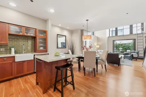 a dining hall with stainless steel appliances granite countertop a stove top oven a dining table and chairs