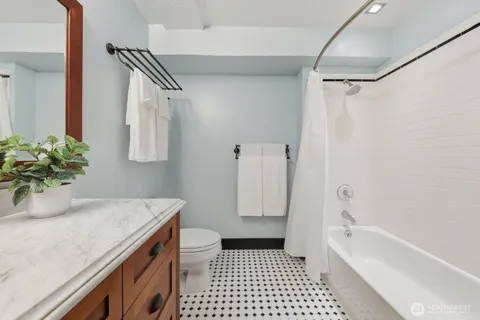 a bathroom with a granite countertop sink a toilet and shower