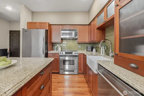 a kitchen with stainless steel appliances granite countertop a sink stove and refrigerator