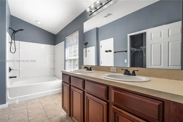 a bathroom with a tub sink and mirror