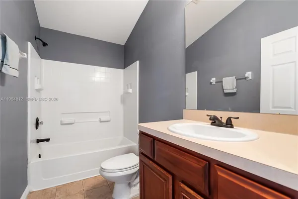 a bathroom with a sink a toilet and a large mirror