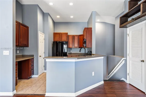 a kitchen with stainless steel appliances granite countertop a sink and a refrigerator