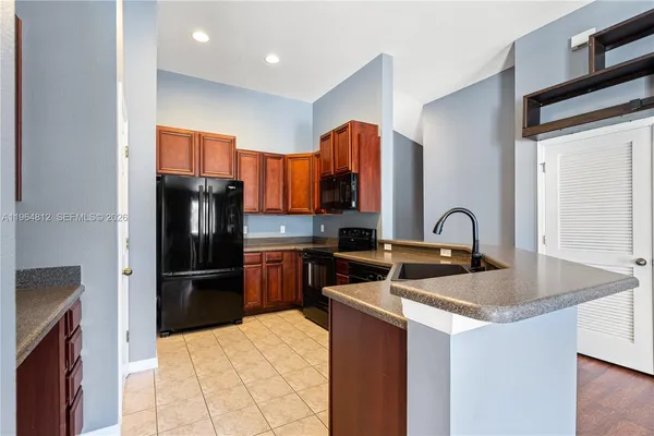 a kitchen with stainless steel appliances granite countertop a refrigerator and a sink
