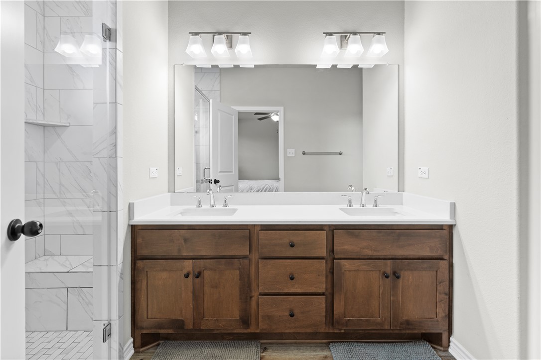 596 J W Martine Road Hearne, TX 77859 - Photo 17 of 36 a bathroom with a sink double vanity and a mirror