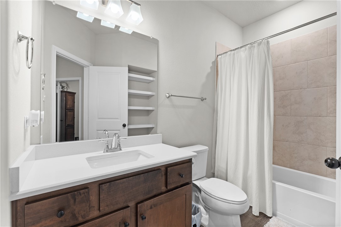 596 J W Martine Road Hearne, TX 77859 - Photo 21 of 36 a bathroom with a sink a toilet a mirror a vanity and shower