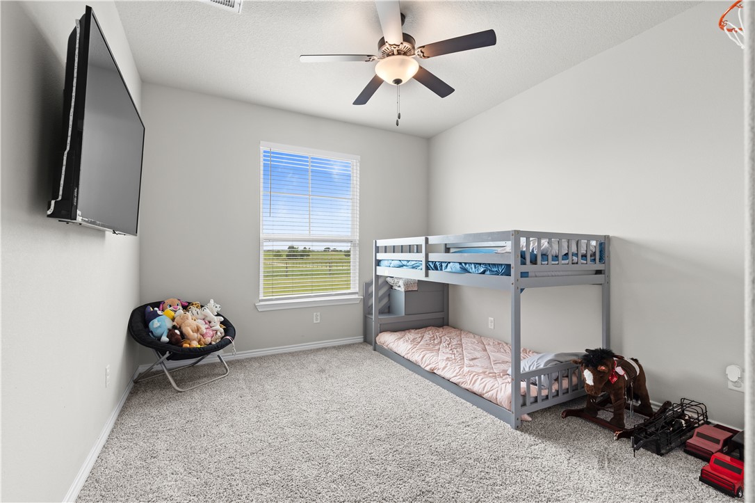 596 J W Martine Road Hearne, TX 77859 - Photo 24 of 36 a living room with a baby crib furniture and a flat screen tv