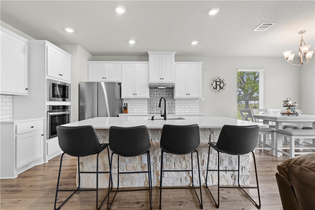596 J W Martine Road Hearne, TX 77859 - Photo 8 of 36 a kitchen with a dining table chairs and refrigerator