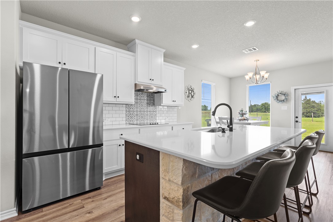 596 J W Martine Road Hearne, TX 77859 - Photo 9 of 36 a kitchen with stainless steel appliances granite countertop a refrigerator a sink a stove a dining table and chairs