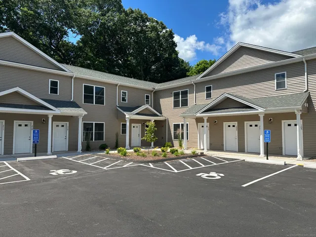 a front view of a house with trees and plants