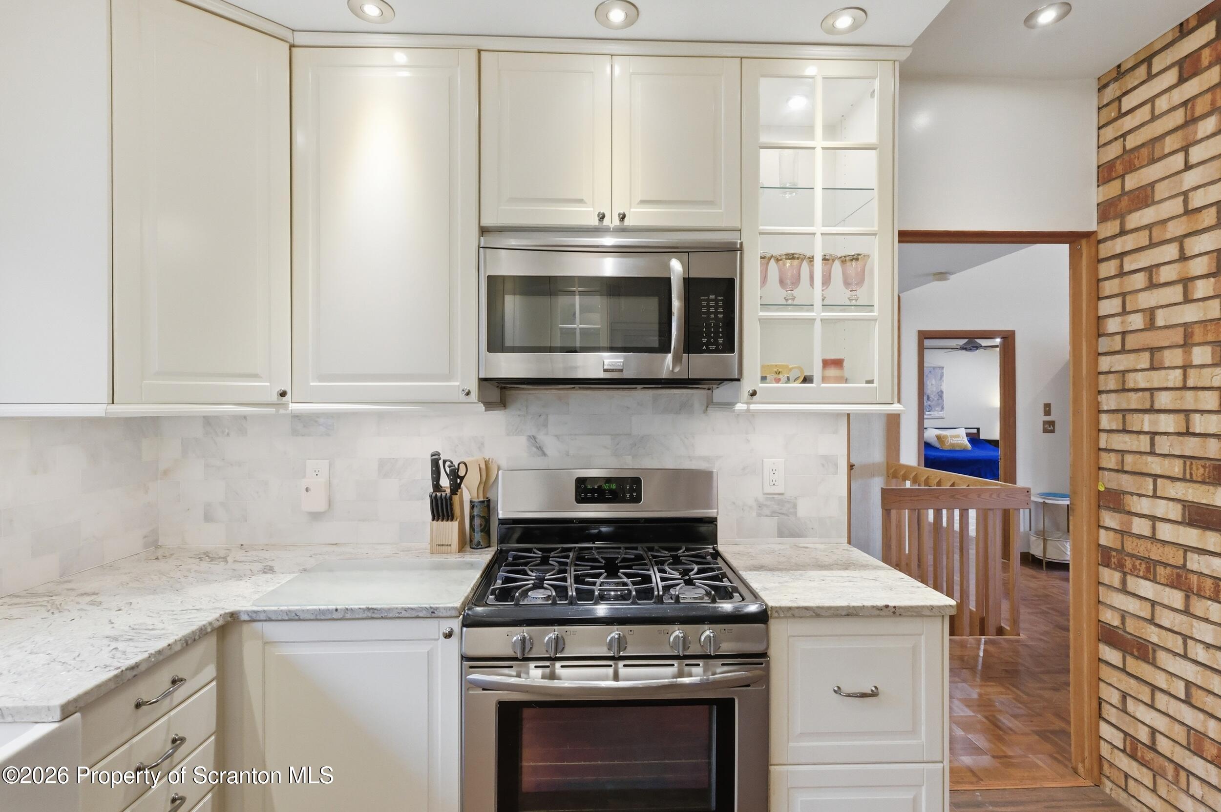 1647 Windmere Place Lake Ariel, PA 18436 - Photo 12 of 65 a kitchen with granite countertop a stove top oven microwave and cabinets