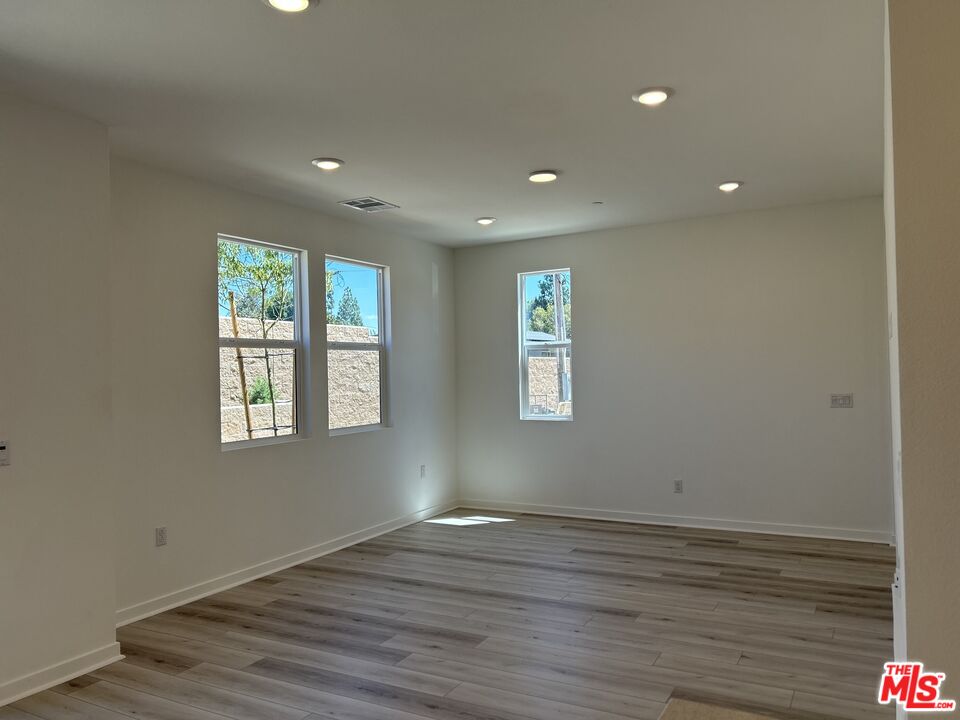 154 Tarragon Way Upland, CA 91786 - Photo 4 of 21 a view of an empty room with wooden floor and a window