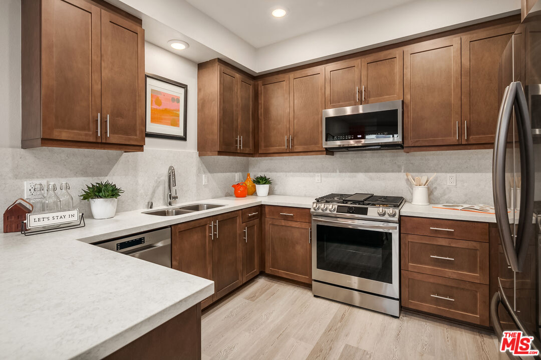 154 Tarragon Way Upland, CA 91786 - Photo 9 of 21 a kitchen with stainless steel appliances granite countertop a sink stove and microwave