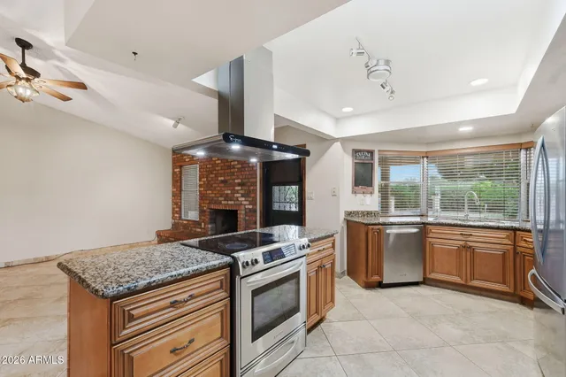 a kitchen with stainless steel appliances granite countertop a stove a sink dishwasher and a refrigerator