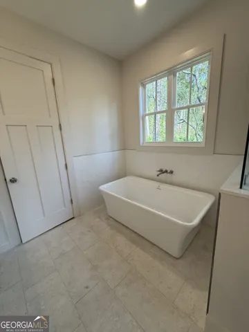 a bathroom with a tub sink and mirror